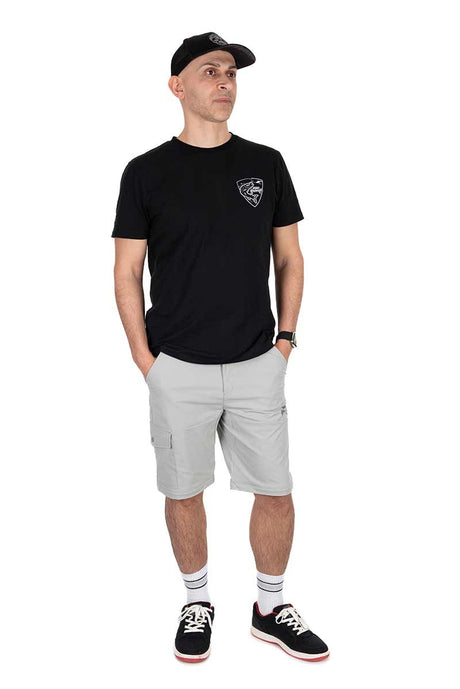 Hombre vistiendo pantalón desmontable gris claro y camiseta negra, ideal para pesca y actividades al aire libre.